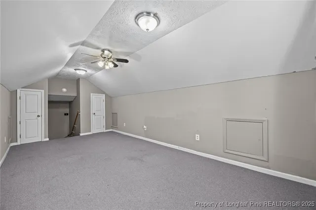 en empty room with windows and ceiling fan
