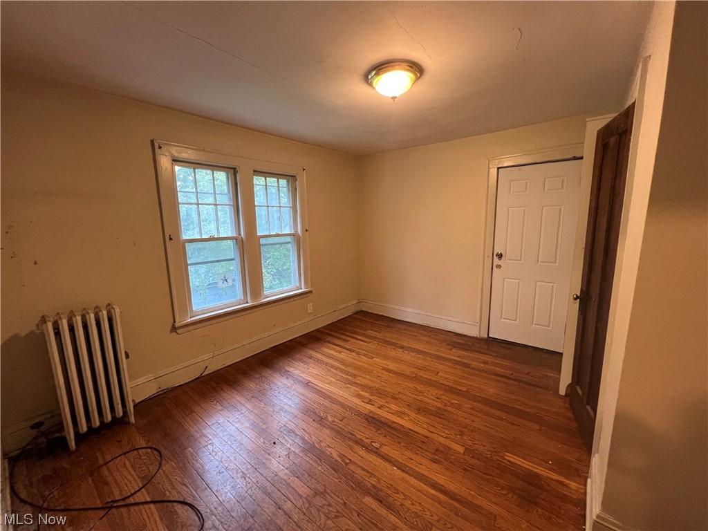 3169 Yorkshire Road Cleveland, OH 44118 - Photo 10 of 15 Hardwood floored empty room featuring radiator heating unit