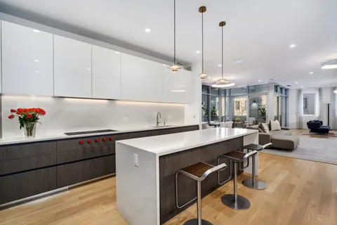 a kitchen that has a sink a stove and a wooden floor