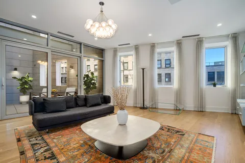 a living room with furniture and a chandelier