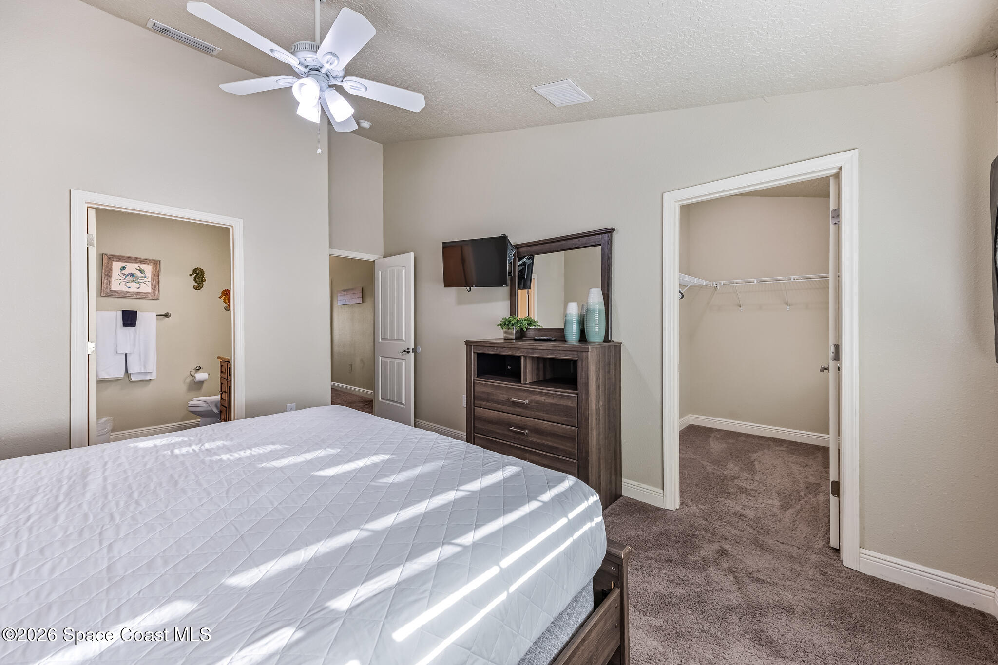 2709 Cutlass Point Lane, Unit 102 Merritt Island, FL 32953 - Photo 12 of 37 a bedroom with a bed and a chandelier