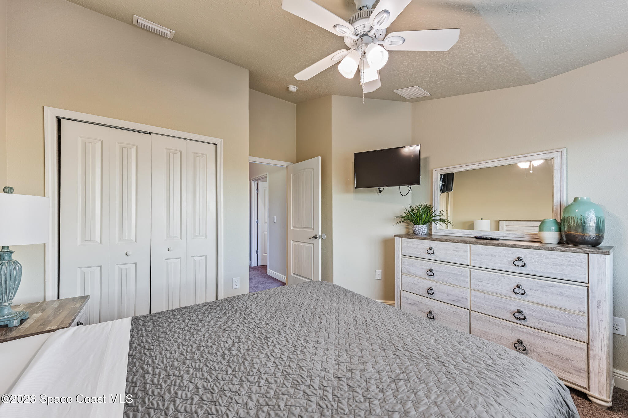 2709 Cutlass Point Lane, Unit 102 Merritt Island, FL 32953 - Photo 16 of 37 a bedroom with a bed a flat screen tv and a dresser