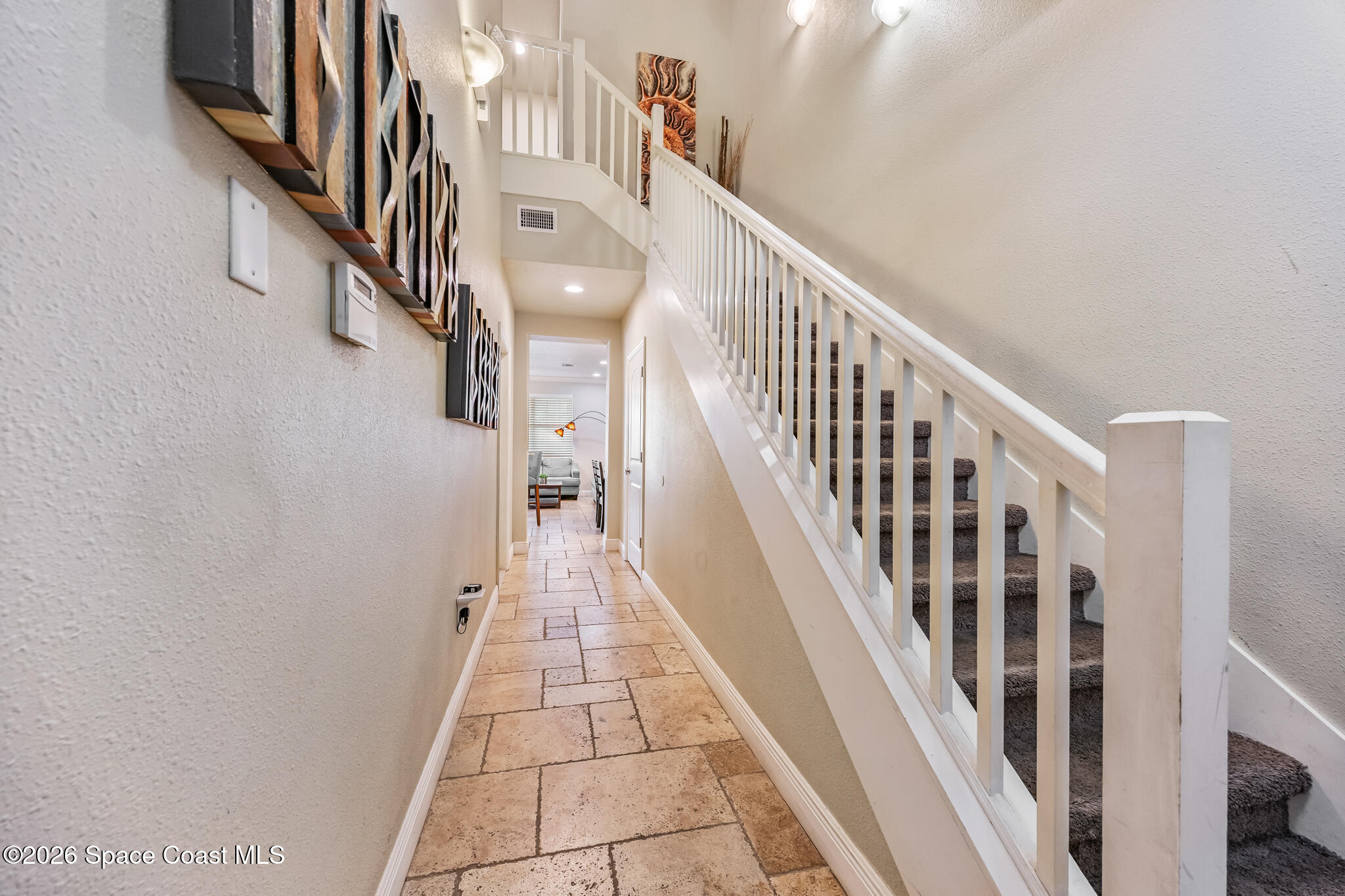 2709 Cutlass Point Lane, Unit 102 Merritt Island, FL 32953 - Photo 9 of 37 a view of staircase with lots of frames on wall and wooden floor