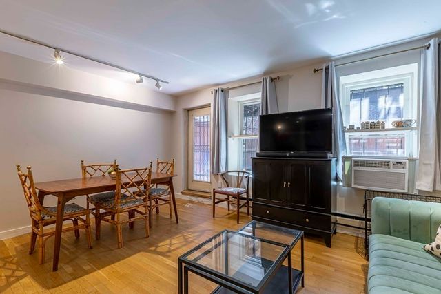 a living room with furniture a flat screen tv and kitchen view