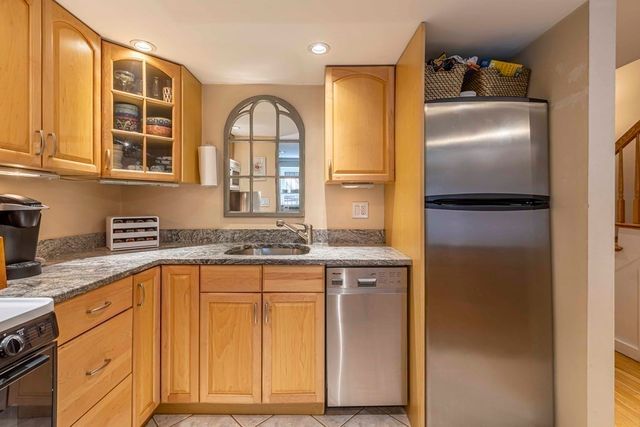 a kitchen with stainless steel appliances granite countertop a refrigerator and a sink