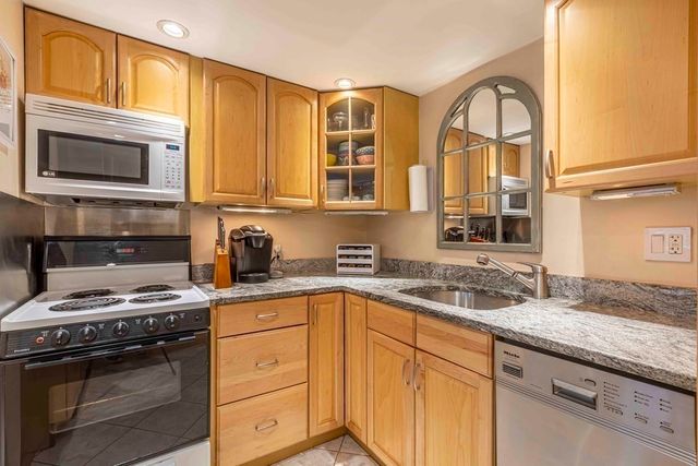 a kitchen with stainless steel appliances granite countertop a stove microwave and cabinets