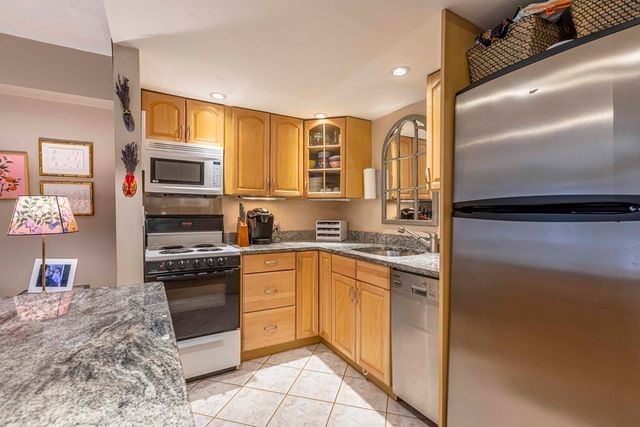 a kitchen with stainless steel appliances granite countertop a stove top oven a sink and dishwasher