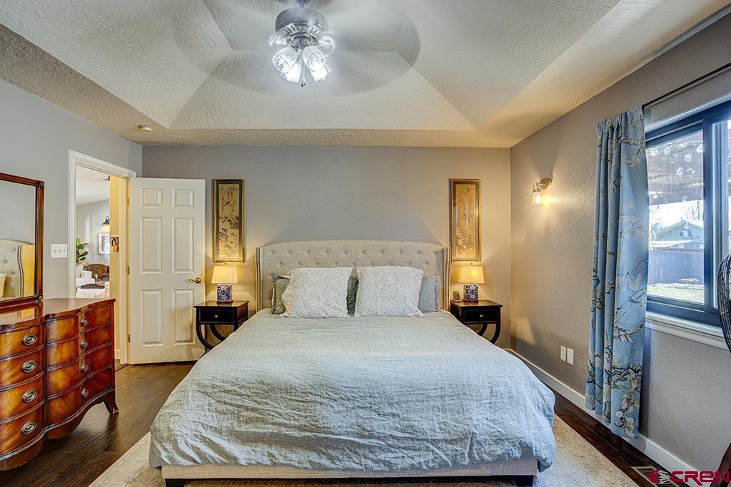 407 Colorado Street Cortez, CO 81321 - Photo 18 of 35 a bedroom with a large bed and a chandelier