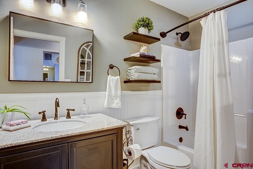 407 Colorado Street Cortez, CO 81321 - Photo 21 of 35 a bathroom with a sink a toilet and shower curtain