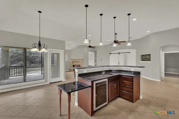 a kitchen with stainless steel appliances granite countertop a stove a sink a counter and chairs