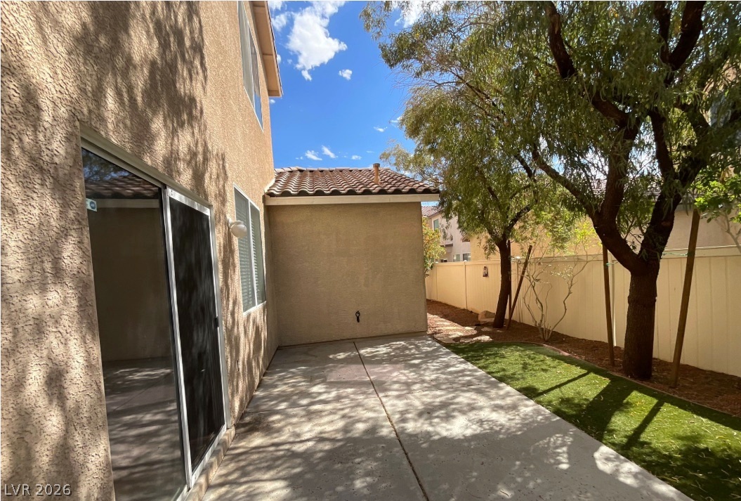 10841 Paradise Road Henderson, NV 89052 - Photo 34 of 35 A private outdoor space features a paved patio, artificial turf, and mature trees for shade.