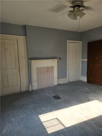 a view of an empty room and a chandelier fan