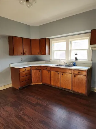 a kitchen with stainless steel appliances granite countertop a sink a stove and wooden floors