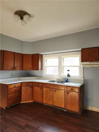 a kitchen with a sink cabinets and wooden floor