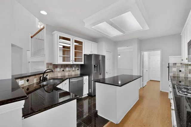 a kitchen with stainless steel appliances granite countertop a sink a stove and a refrigerator