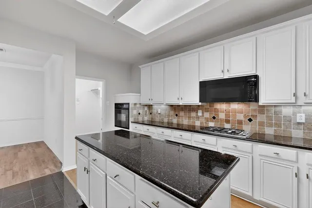 a kitchen with stainless steel appliances granite countertop a sink stove and microwave