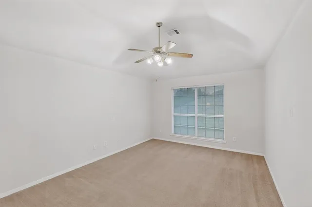an empty room with closet and a chandelier fan