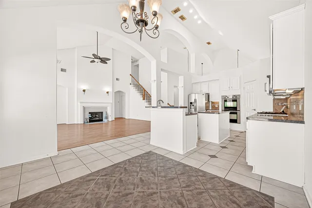 a view of empty room with wooden floor and ceiling fan