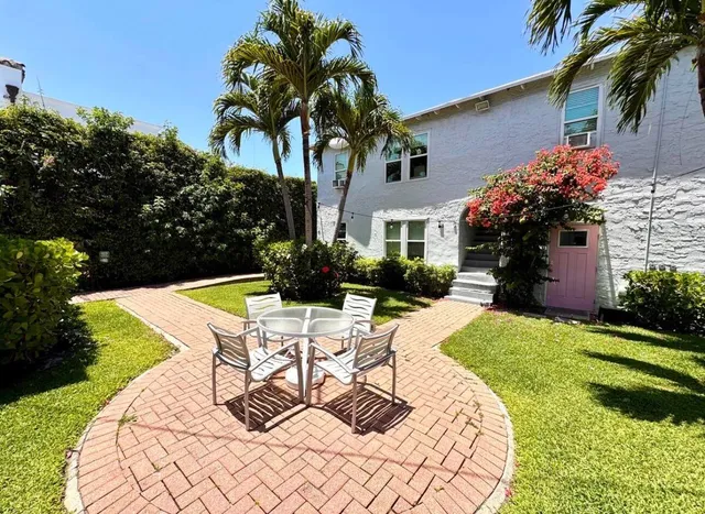 a front view of a house with a yard and a lot of flower plants