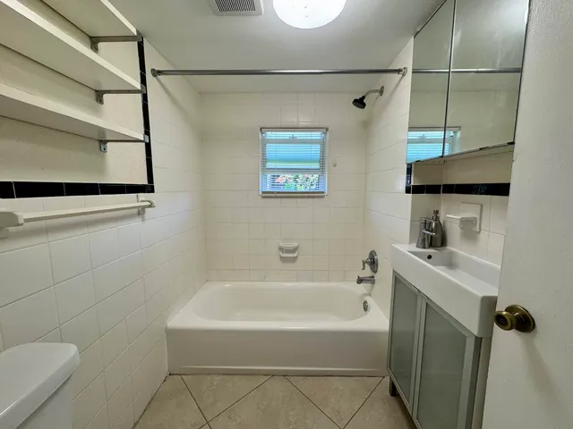 a bathroom with a bathtub a sink a toilet and a shower