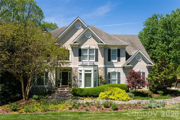a front view of a house with a yard and potted plants