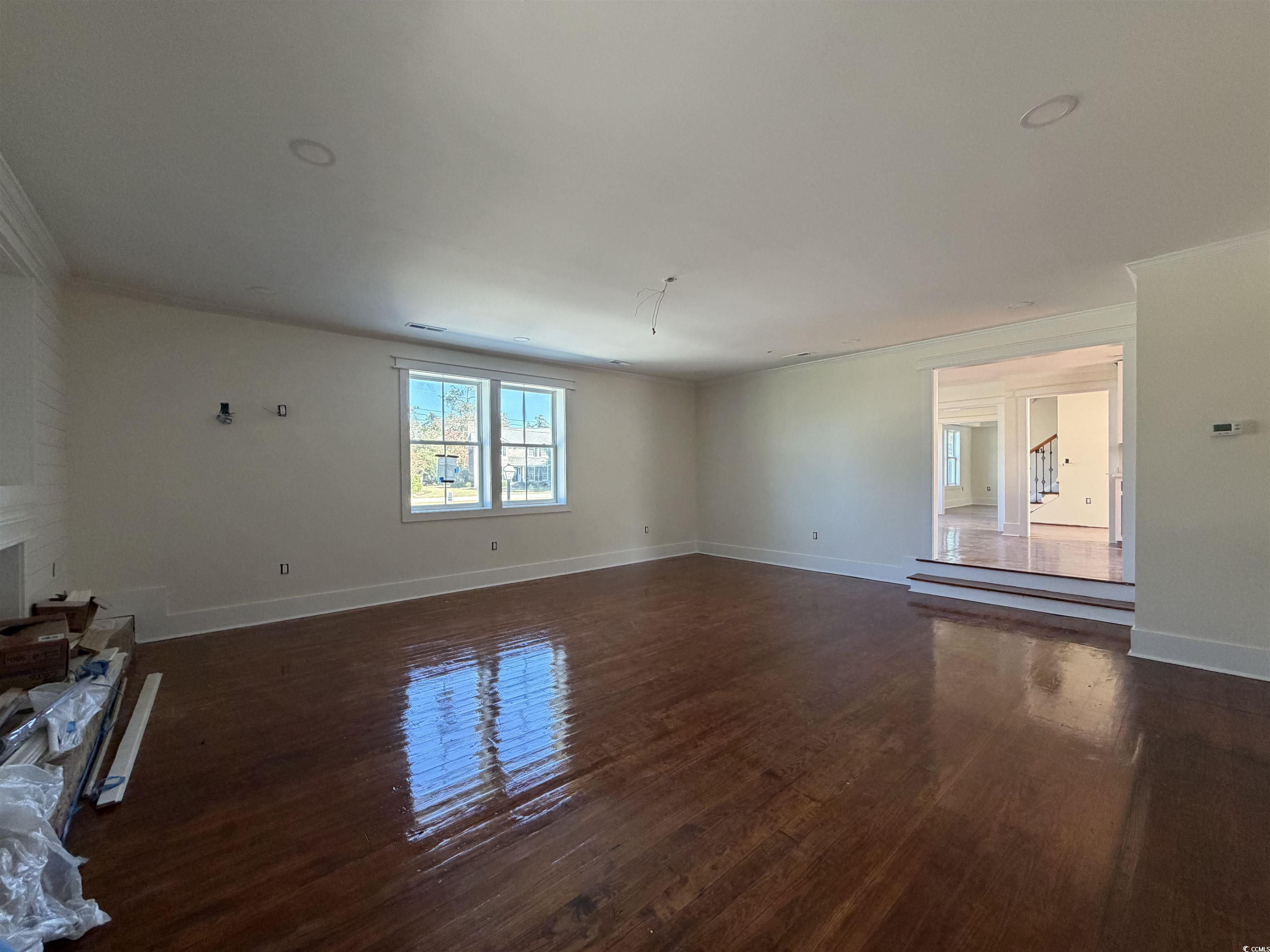 1003 Winding Road Conway, SC 29526 - Photo 11 of 32 Unfurnished living room featuring dark wood-style floors and ornamental molding