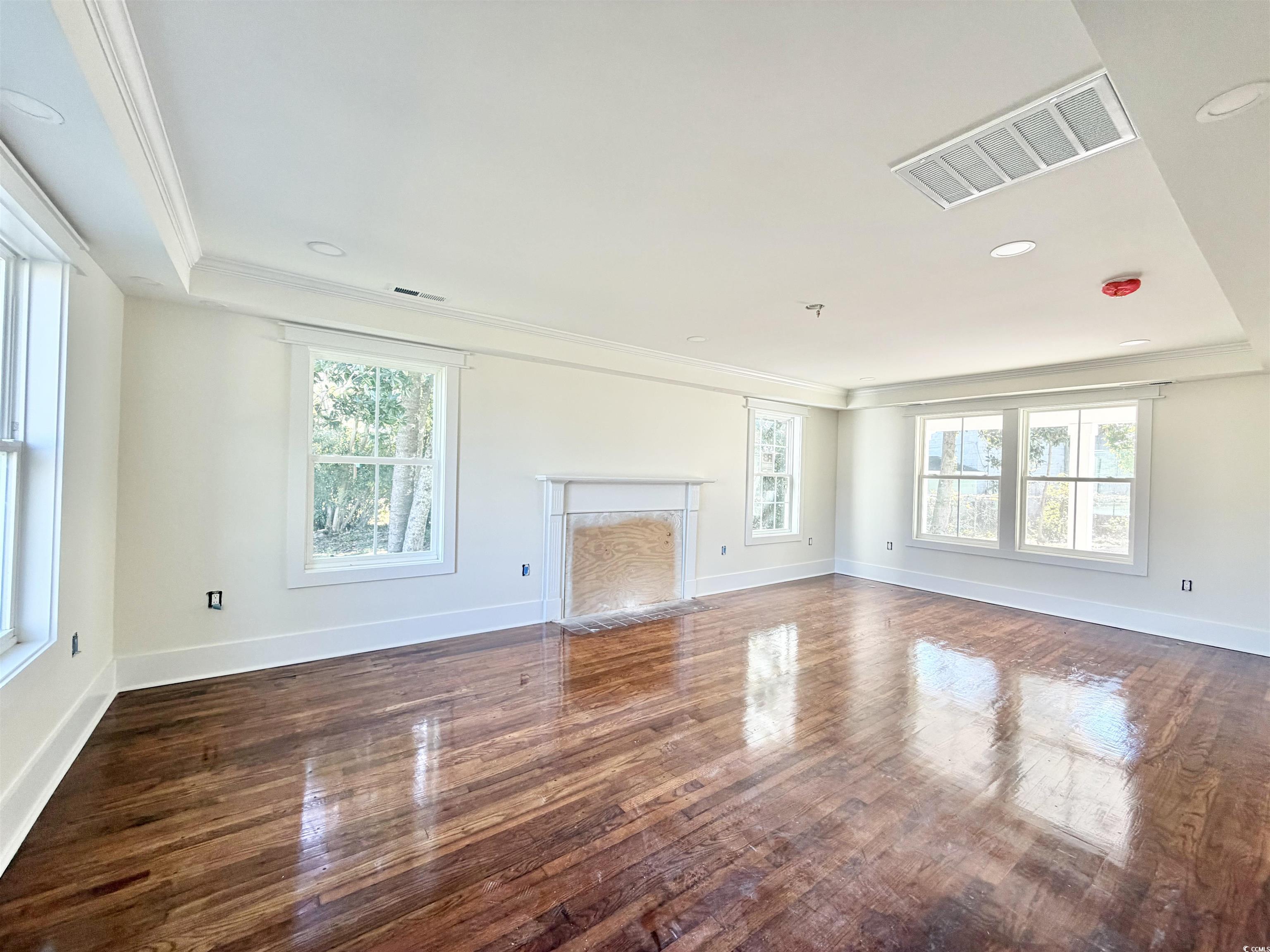 1003 Winding Road Conway, SC 29526 - Photo 4 of 32 Unfurnished living room featuring healthy amount of natural light, ornamental molding, a premium fireplace, dark wood-style floors, and recessed lighting