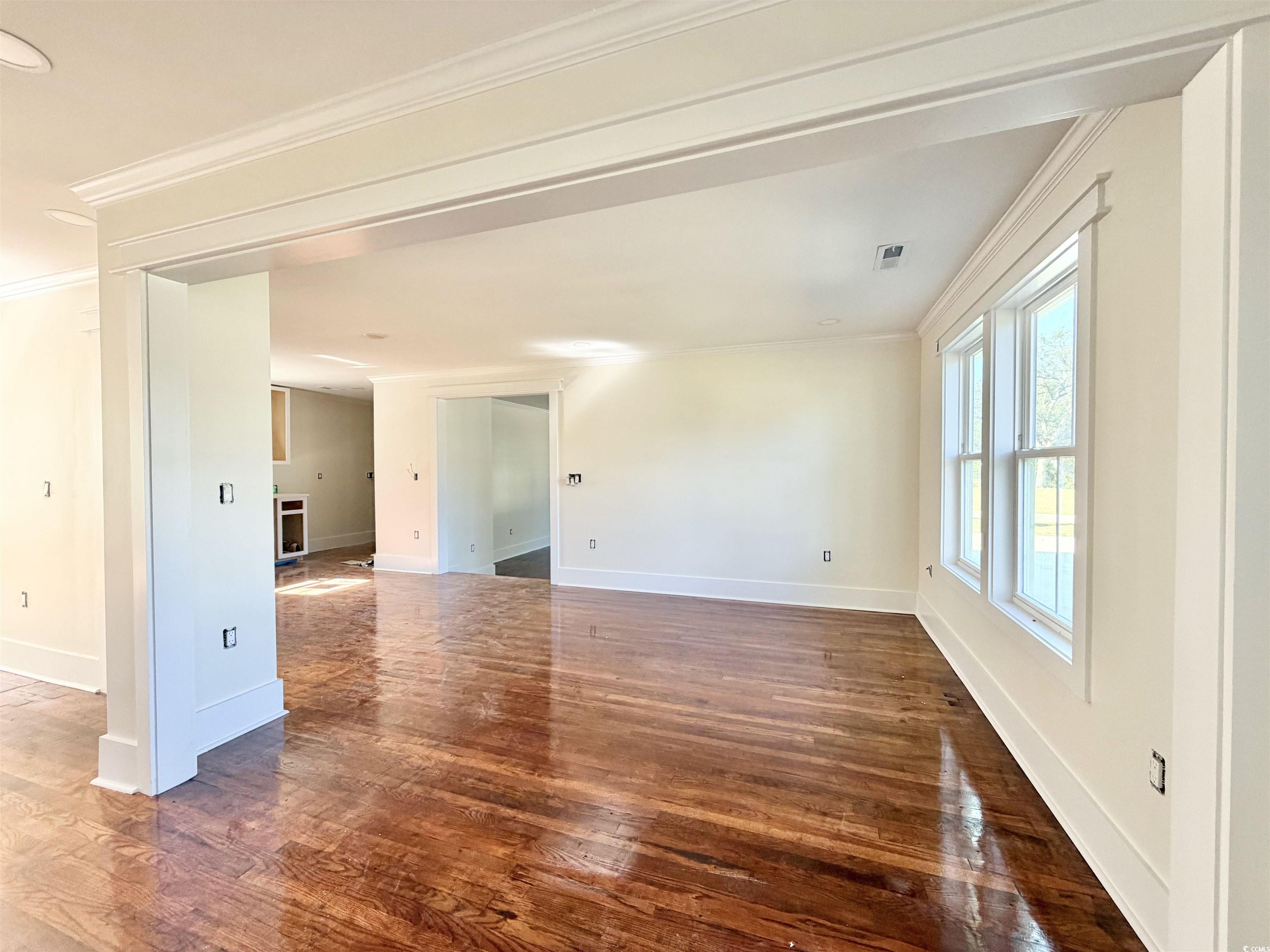 1003 Winding Road Conway, SC 29526 - Photo 6 of 32 Spare room with crown molding and dark wood-style floors