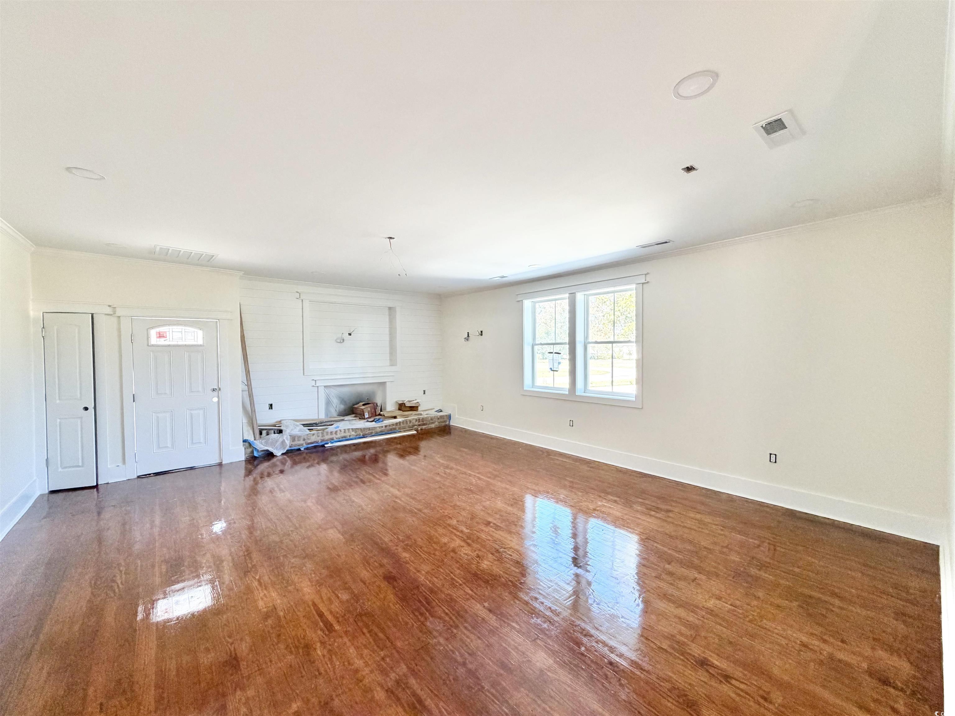 1003 Winding Road Conway, SC 29526 - Photo 10 of 32 Living area featuring dark wood-style floors, a fireplace with raised hearth, and crown molding