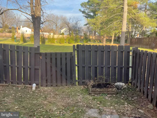 a view of a backyard with wooden fence