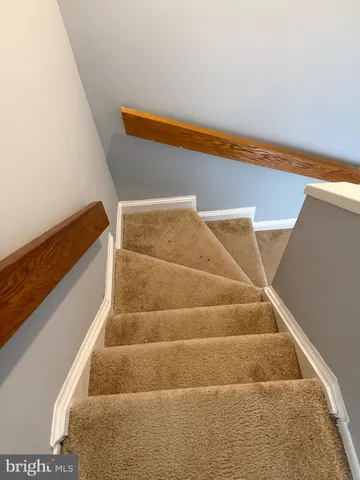 a view of staircase with white walls and white door