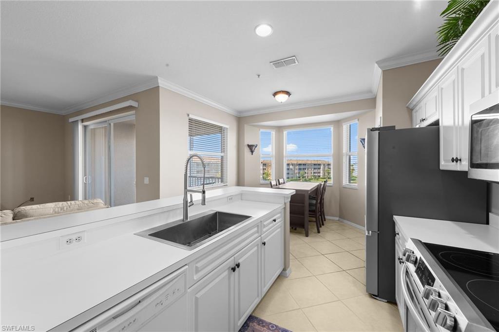 8570 Kingbird Loop, Unit 547 Estero, FL 33967 - Photo 6 of 50 a kitchen with stainless steel appliances granite countertop a sink stove and refrigerator