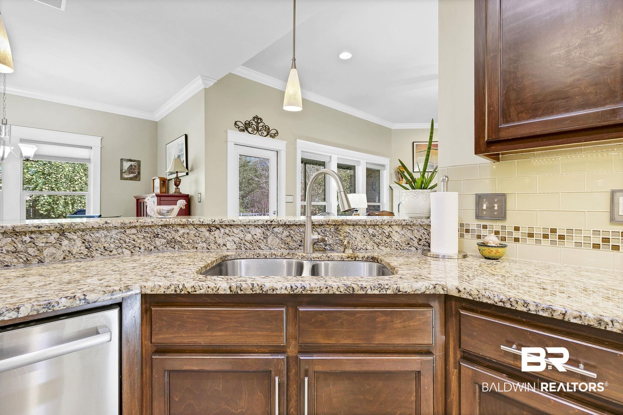 20105 Bunker Loop Fairhope, AL 36532 - Photo 20 of 65 Kitchen with backsplash, crown molding, light stone countertops, stainless steel dishwasher, and a sink