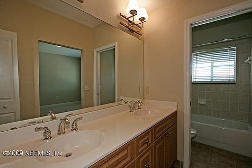 9745 Touchton Road, Unit 927 Jacksonville, FL 32246 - Photo 6 of 22 a bathroom with a tub sink double vanity and a mirror