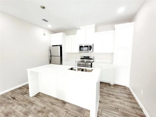 a kitchen with a refrigerator and a stove top oven