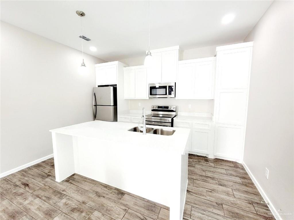 815 East Starr Road, Unit C Mercedes, TX 78570 - Photo 8 of 12 a kitchen with a refrigerator and a stove top oven
