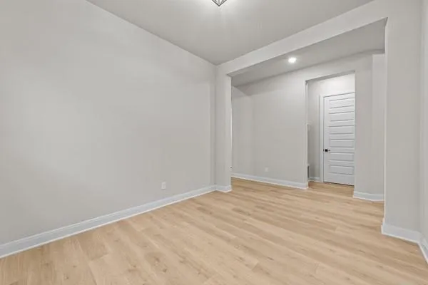 a view of an empty room with wooden floor