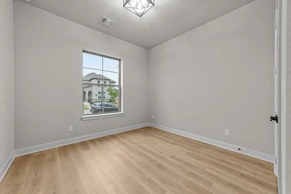 a view of an empty room with wooden floor