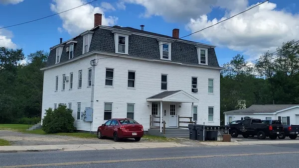 a car parked in front of a white building