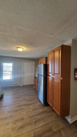 a view of a refrigerator in kitchen and wooden floor