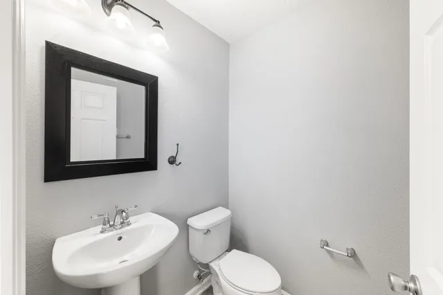 a bathroom with a toilet sink and mirror