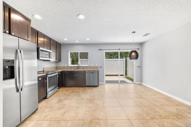 a large kitchen with a large counter top stainless steel appliances and cabinets