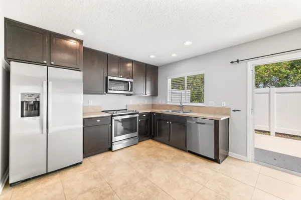 a kitchen with stainless steel appliances granite countertop a refrigerator and a stove