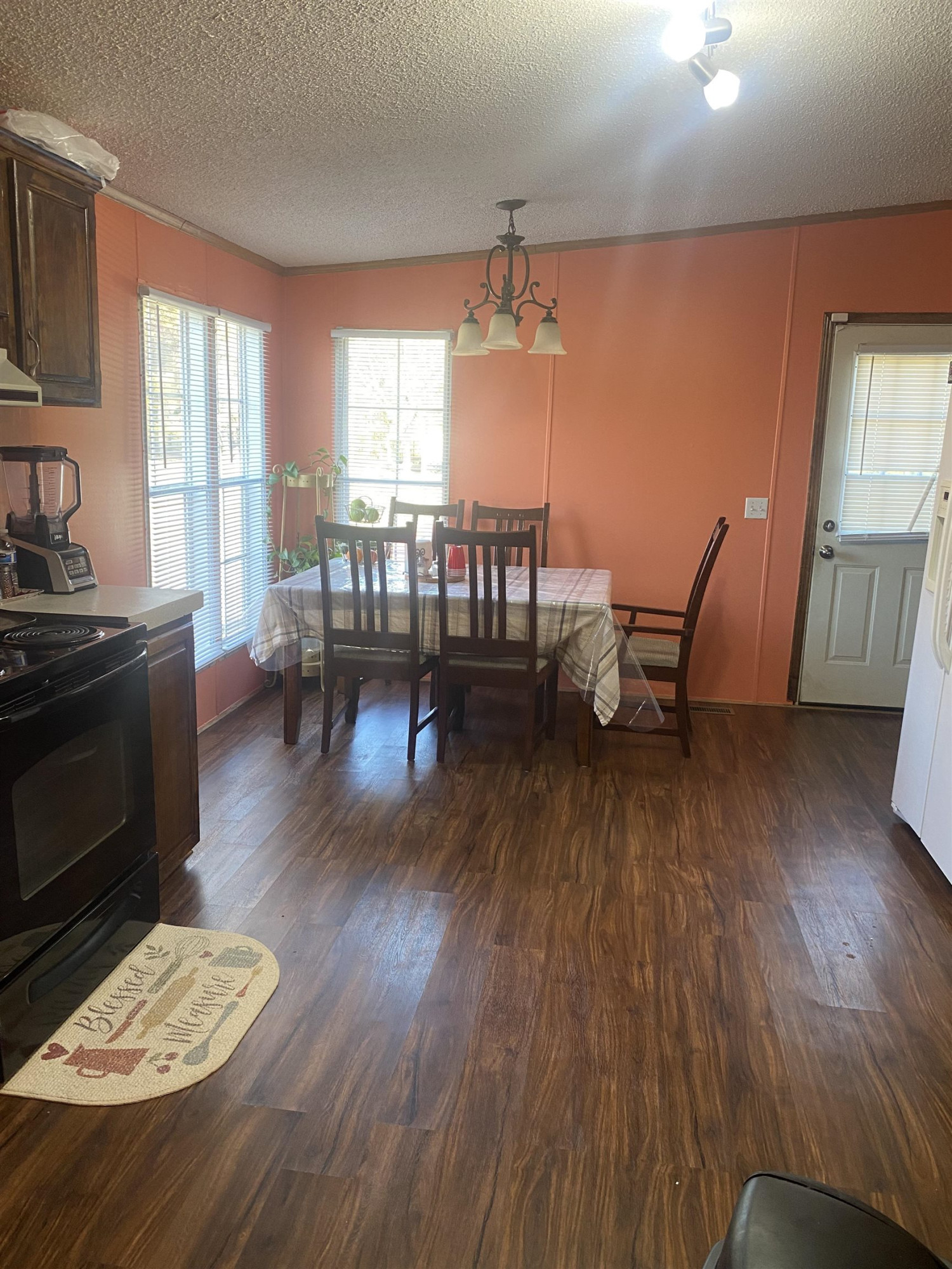 1658 Jack Clement Road Stem, NC 27581 - Photo 3 of 8 a dining room with wooden floor a chandelier a glass table and chairs