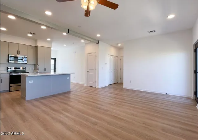 a large kitchen with stainless steel appliances granite countertop a granite counter tops and a wooden floors