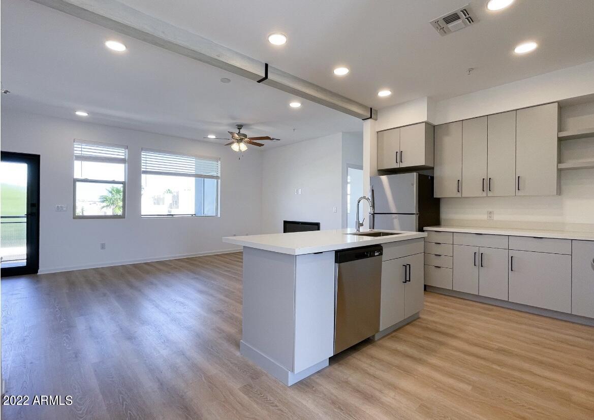 12412 North Saguaro Boulevard, Unit 303 Fountain Hills, AZ 85268 - Photo 17 of 48 a kitchen with stainless steel appliances granite countertop a sink cabinets and wooden floor
