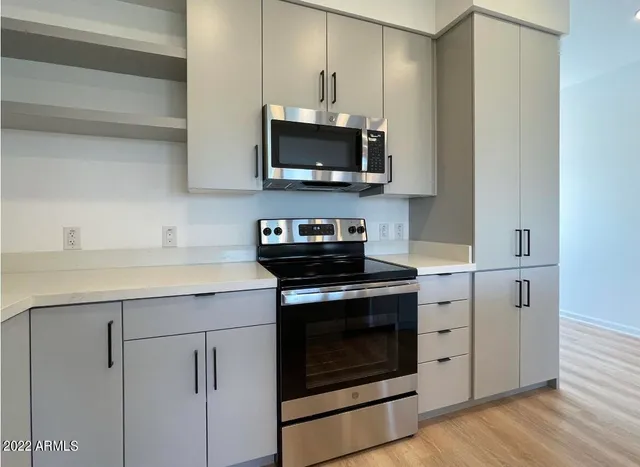 a kitchen with stainless steel appliances granite countertop a stove and a microwave