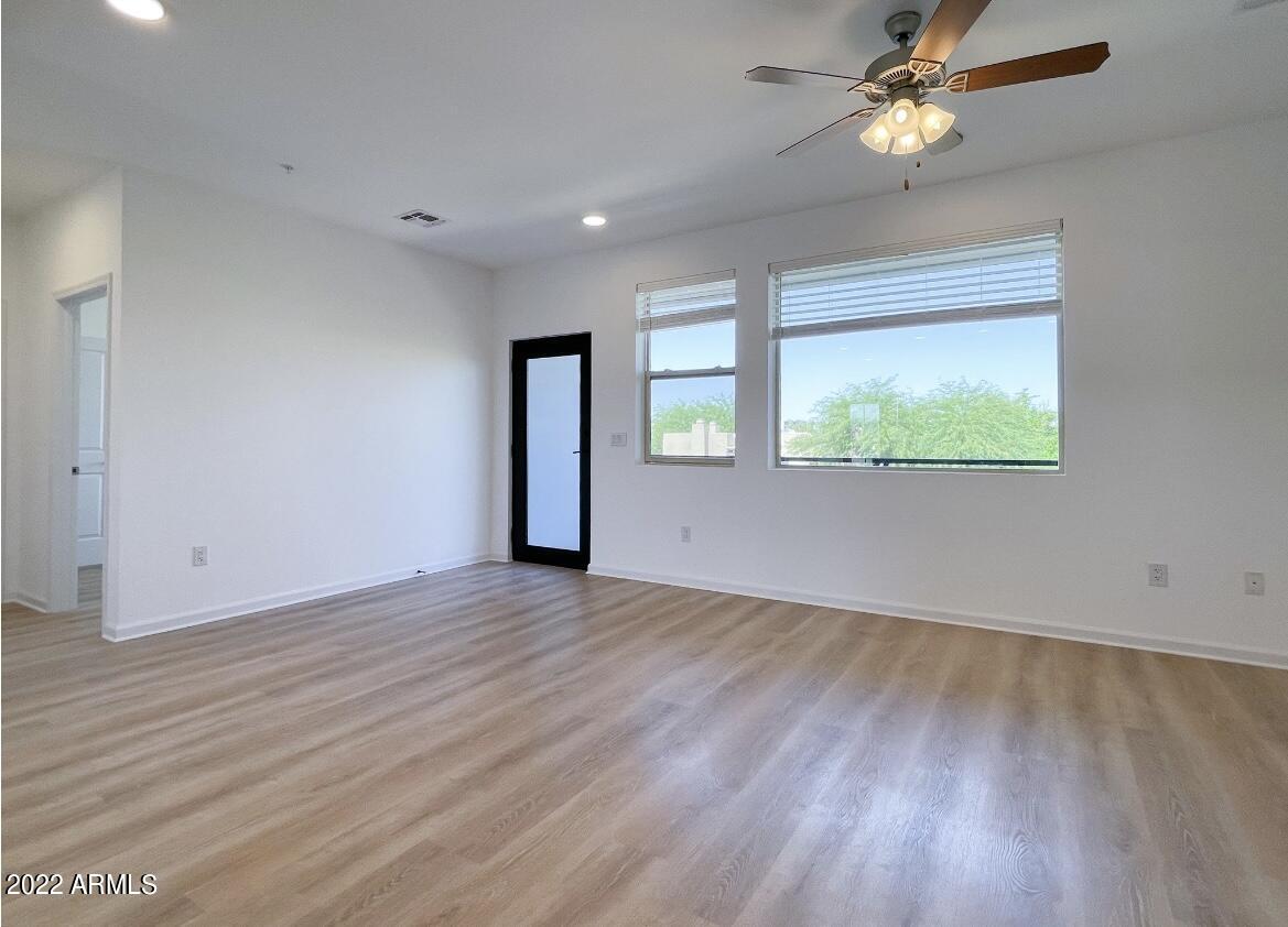 12412 North Saguaro Boulevard, Unit 303 Fountain Hills, AZ 85268 - Photo 24 of 48 an empty room with wooden floor fan and windows