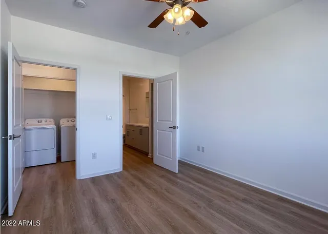 an empty room with wooden floor and chandelier