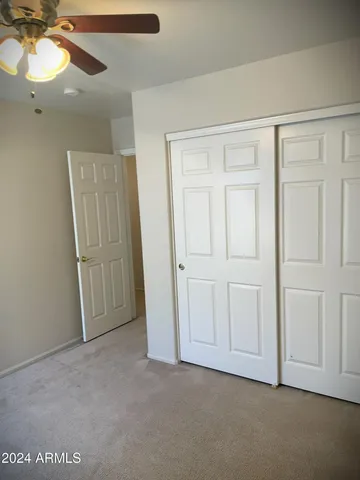 a view of an empty room and a ceiling fan